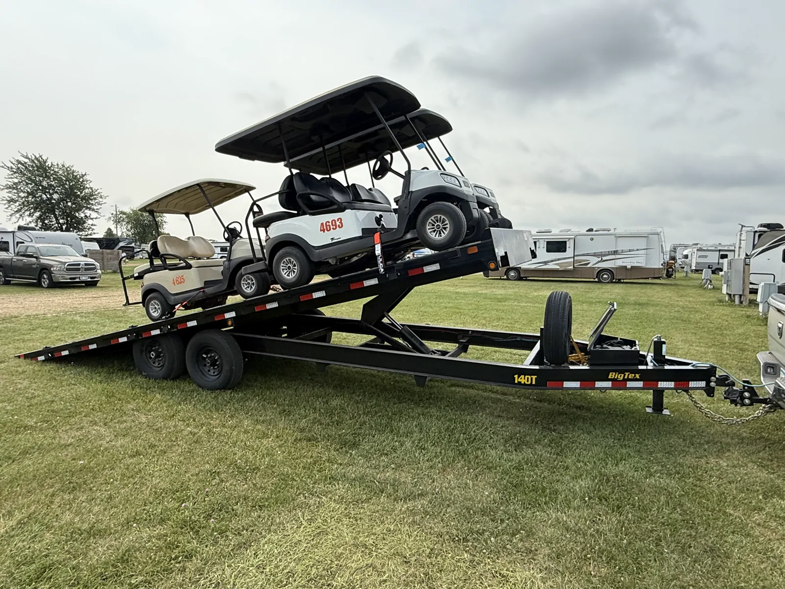 Tilt deckover trailer loaded with two golf carts in Wisconsin